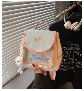 Close-up of pastel backpack with heart-shaped window and cute plush eye charm