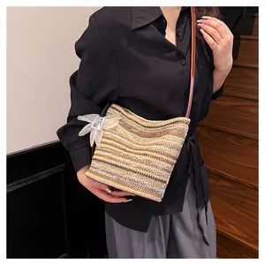 Detail of a rainbow striped straw shoulder bag with a translucent white organza bow