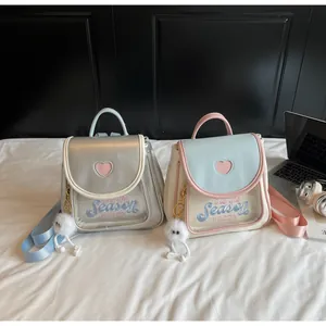 Detailed view of dopamine ita bags in silver and blue with heart patterns and plush charms