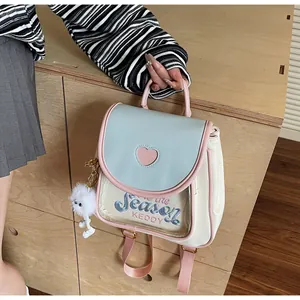 Detail view of mini pastel blue backpack with pink heart cutout and plush bunny charm