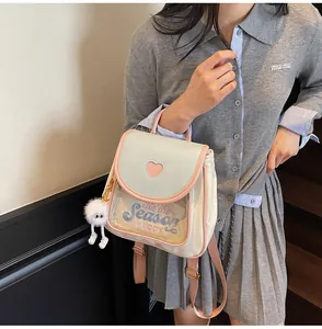 Detail of cute school backpack with heart-shaped window and plush monster charm