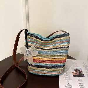 Rainbow striped straw shoulder bag with brown leather strap and white floral charm