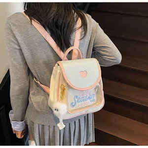 Close-up of heart-shaped window on cream backpack with plush mascot and embroidery