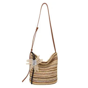 Rainbow stripe woven straw bucket bag with floral charm and adjustable leather strap