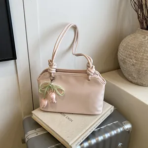 Elegante borsa a secchiello rosa chiaro con ciondolo a tulipano e tracolla con nodo