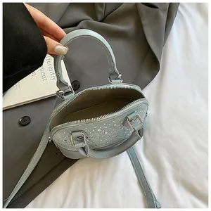 Light blue mini shell bag with silver rhinestones and top handle seen from above