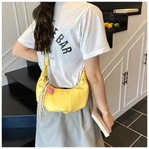 Détail du sac croissant jaune en similicuir plissé avec pendentif cœur rose