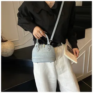 Detail of light blue shell bag with tweed texture, rhinestones and leather handle