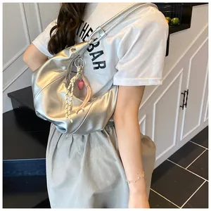 Détail du sac croissant argenté avec breloque cœur rose et cordon tressé