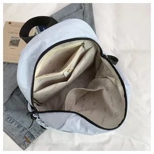 Innenansicht des hellblauen Nylon-Rucksacks mit Reißverschlussfach und Futterdetails