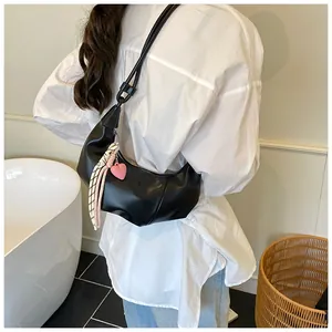 Détail du sac hobo noir avec pendentif cœur rose et décoration d'écharpe à fleurs