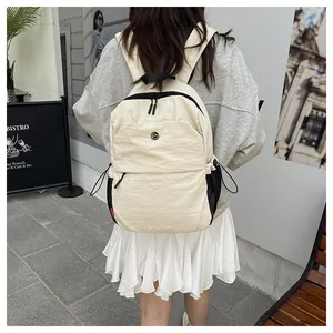 Detailansicht eines cremeweißen Nylonrucksacks mit schwarzem Reißverschluss und Netztasche