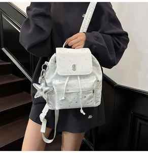 Detail of white star pattern backpack with silver J logo and plush star charm