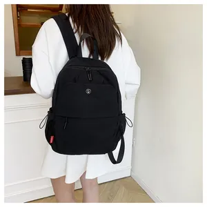 Detailansicht eines schwarzen Nylonrucksacks mit rotem HOBORN-Label und seitlicher Netztasche