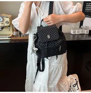 Close-up of black canvas star pattern backpack with silver starfish charm detail