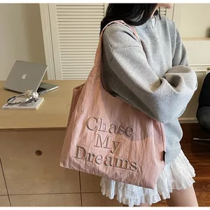 Borsa tote rosa con ricamo Chase My Dreams in un ambiente di stile di vita casual