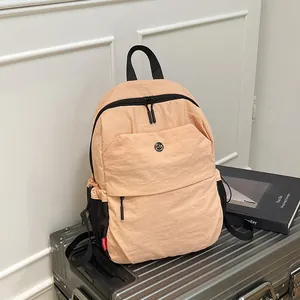 Pfirsichfarbener leichter Freizeitrucksack mit großem Fassungsvermögen auf dem Koffer