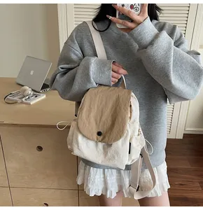 Detail of canvas backpack featuring khaki flap cover and contrast button closure