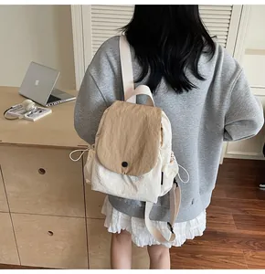 Detail view of canvas backpack with drawstring side pockets and adjustable shoulder straps