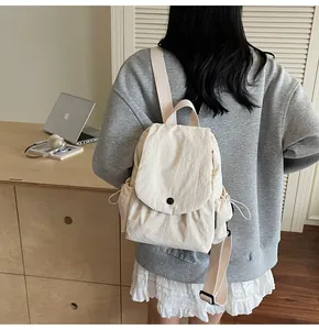 Detail view of the cream pleated nylon mini backpack texture and khaki straps