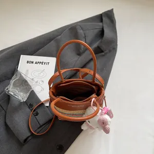 Borsa a secchiello in paglia bicolore con ciondolo a coniglio in peluche per donna