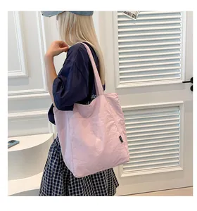 Close-up of light pink lightweight tote bag with minimalist side label on fabric