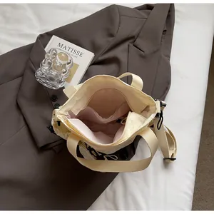 Interior view showing spacious main compartment and side pocket of the cream sports crossbody bag