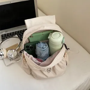 Large capacity beige nylon backpack showing organized interior with tablet and umbrella