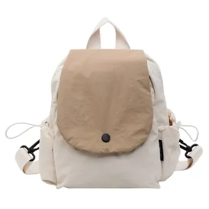 Minimalist canvas backpack in cream and light brown with a flap cover and side pockets