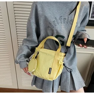 Detail of yellow mini crossbody bag with matching round coin purse and drawstring feature