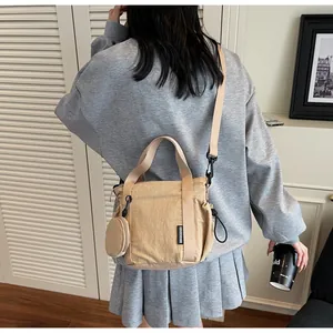 Khaki nylon crossbody bag with mini round pouch shown on a model in Japanese style
