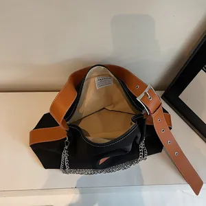 Large black nylon tote bag with brown leather straps and silver metal chain detail