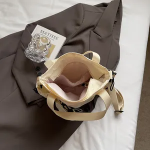 Chic beige nylon tote with pink lining, adjustable strap, and elegant daily styling