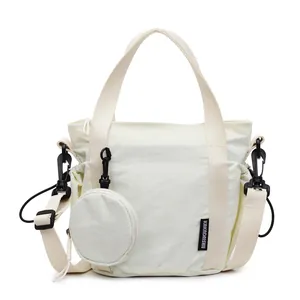 Creamy white nylon sports crossbody bag with a small round coin pouch and adjustable strap