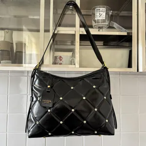 Detail of black quilted shoulder bag with diamond pattern, sparkling rhinestones and gold buckle