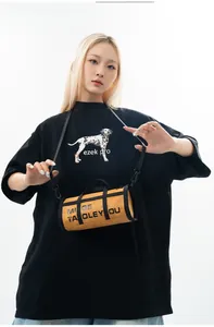 Detail of yellow barrel crossbody bag featuring black lettering and nylon strap
