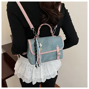 Detalle de mini mochila azul con ribete de cuero rosa y colgante de estrella
