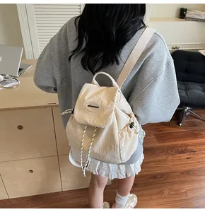 Détail du sac à dos beige à cordon en nylon minimaliste avec rabat et logo discret