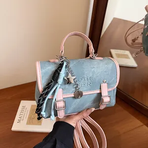 Mini bolso bandolera de mezclilla azul claro con ribete de cuero rosa y colgante estrella
