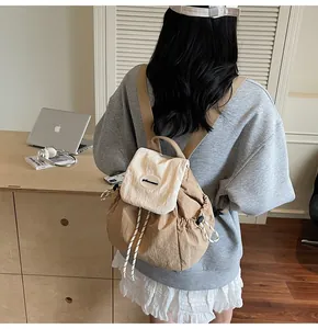 Détail d'un sac à dos de voyage kaki minimaliste avec rabat brodé et cordon de serrage