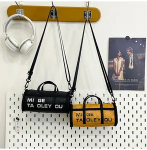 Detailed view of black and yellow cylinder bags with wrinkled texture and adjustable straps