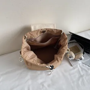 Sac à dos à cordon beige minimaliste avec un grand compartiment et une poche zippée