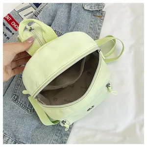 Detailansicht der Innenseite des grünen Nylon-Rucksacks mit Logo und Reißverschluss