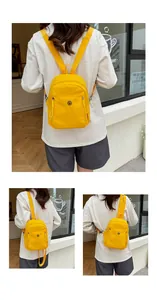 Detailansicht eines hellgelben Nylon-Rucksacks mit rundem Logo und verstellbaren Trägern