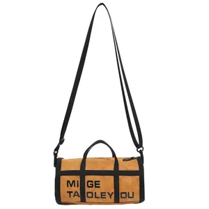 Retro brown cylinder bag with black straps and top handles on a white background