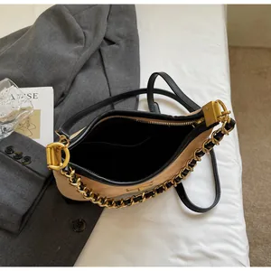Vue de dessus du sac hobo en cuir beige avec bordure noire et chaîne dorée élégante