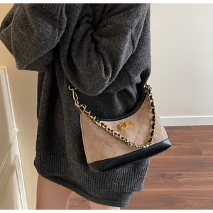 Détail du sac à bandoulière matelassé en daim avec chaîne dorée et fermoir pivotant