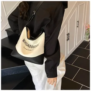 Détail d'un sac seau en toile noir et blanc minimaliste avec bandoulière réglable