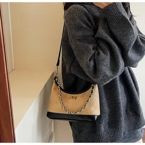 Détail du sac hobo en daim kaki avec cuir noir et fermoir rotatif en métal doré élégant
