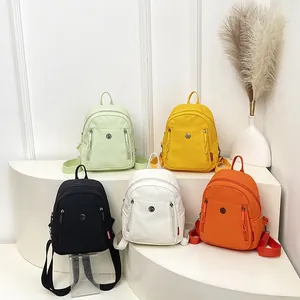 Mini-Damenrucksack aus Nylon in fünf Farben, präsentiert auf minimalistischen Podesten